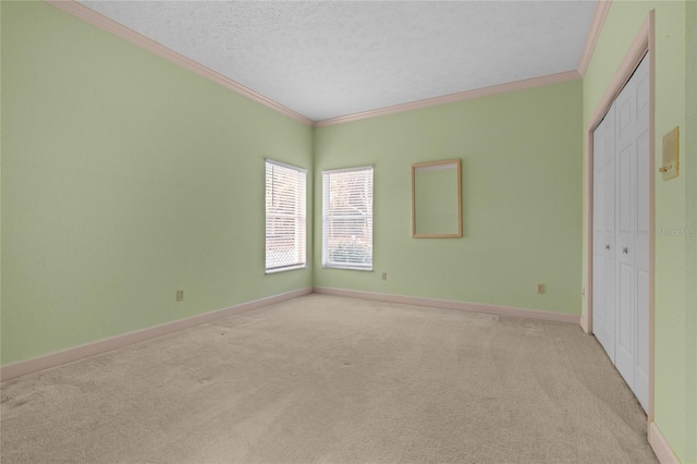 unfurnished bedroom featuring light carpet, a closet, a textured ceiling, and ornamental molding