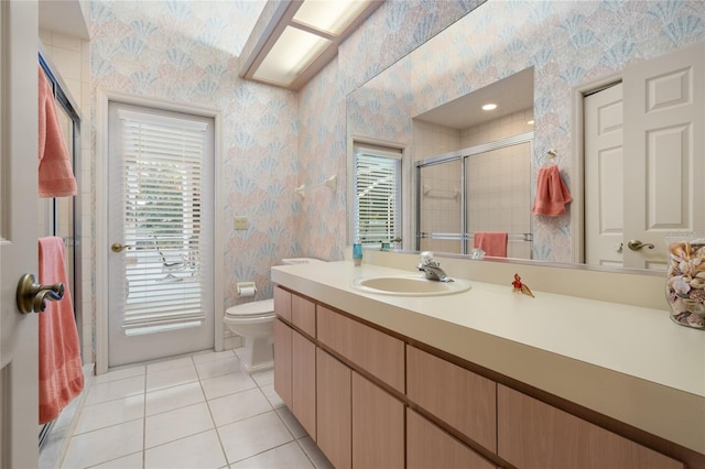 bathroom with toilet, tile patterned flooring, vanity, and walk in shower