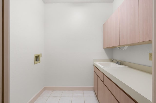 laundry area featuring cabinets, hookup for a washing machine, light tile patterned flooring, and sink