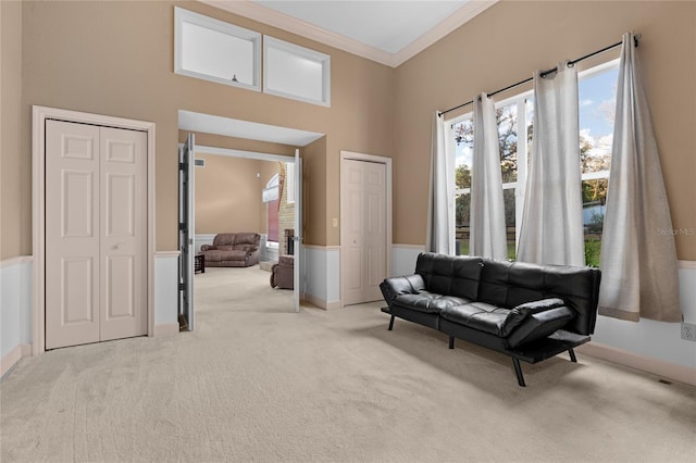 sitting room featuring ornamental molding and light carpet