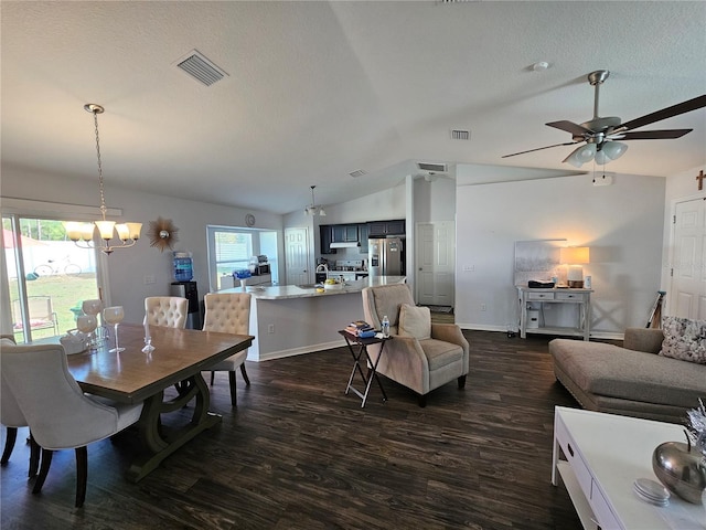 dining room with visible vents, ceiling fan with notable chandelier, dark wood-style floors, and vaulted ceiling