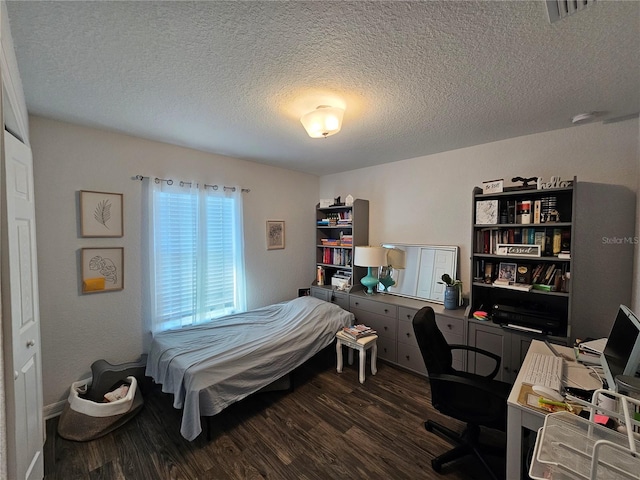 bedroom with visible vents, a textured ceiling, and dark wood-style flooring