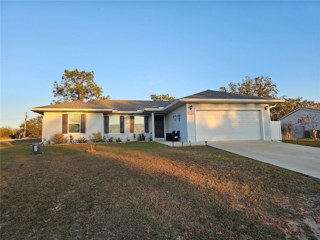 ranch-style house featuring a garage, concrete driveway, a front yard, and stucco siding