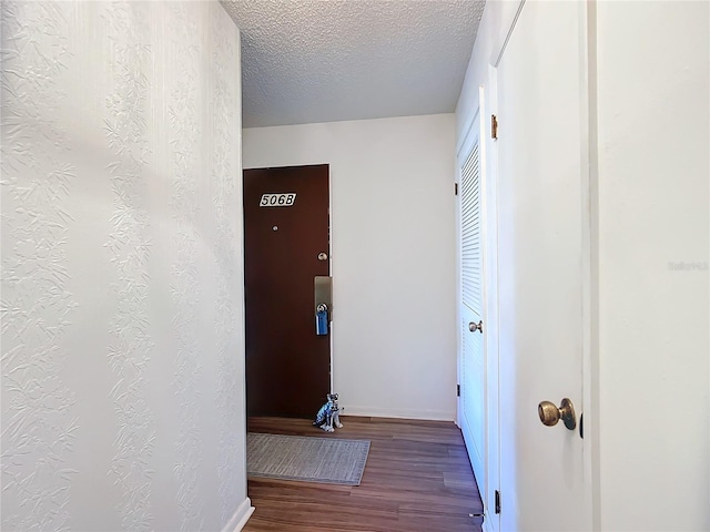 hall featuring hardwood / wood-style flooring and a textured ceiling