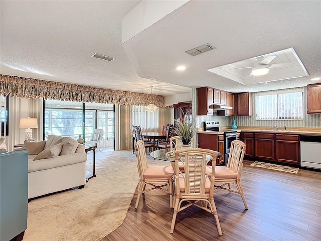 dining space with ceiling fan, light hardwood / wood-style floors, sink, and a wealth of natural light