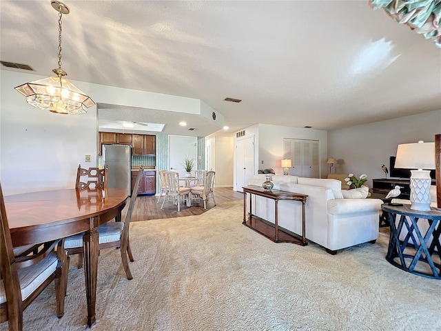 dining space with a chandelier and light colored carpet