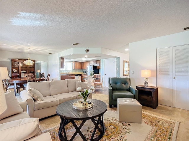 living room featuring light carpet and a textured ceiling