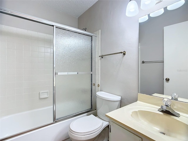 full bathroom featuring vanity, toilet, bath / shower combo with glass door, and a textured ceiling