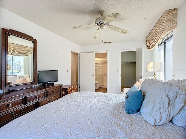 bedroom with multiple windows, ceiling fan, a closet, and a textured ceiling