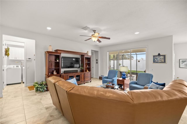 living room featuring ceiling fan, light tile patterned floors, and washer / dryer