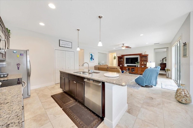 6407 SW 45th Ave, Ocala, FL 34474 - kitchen with stainless steel dishwasher, a sink, dark brown cabinetry, decorative light fixtures, and light stone counters