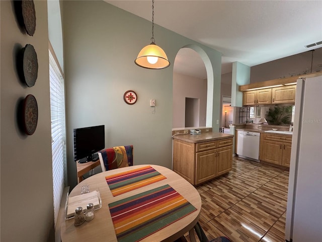 kitchen with pendant lighting, dishwasher, light brown cabinets, backsplash, and white fridge