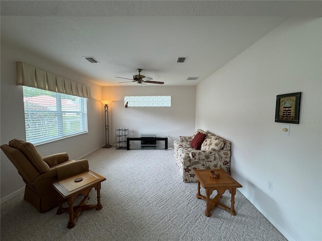 living area featuring carpet and ceiling fan