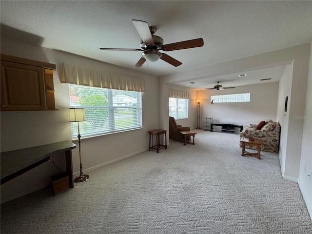 sitting room with ceiling fan and light carpet