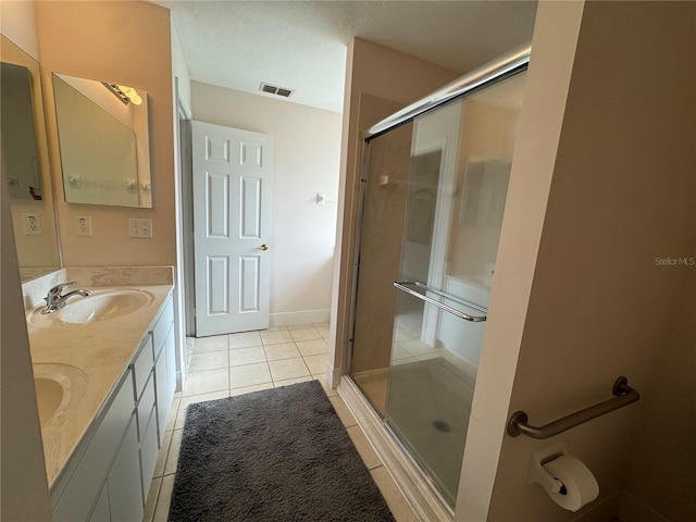 bathroom featuring tile patterned floors, vanity, and a shower with shower door