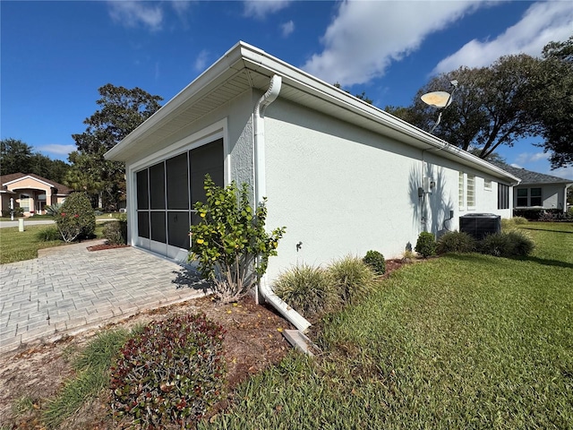 view of side of home featuring a yard and cooling unit