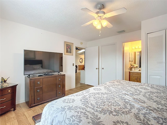 bedroom featuring connected bathroom, ceiling fan, light hardwood / wood-style floors, and a textured ceiling