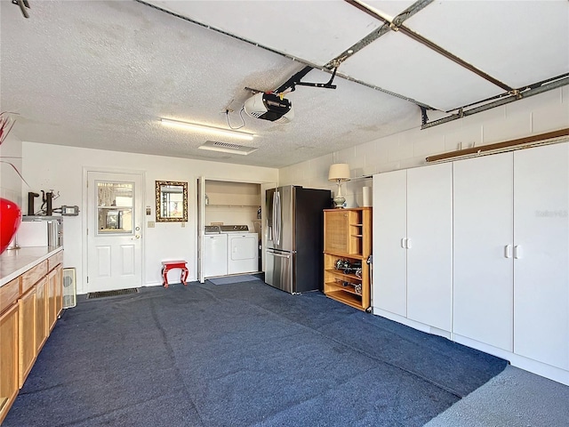 garage with separate washer and dryer, stainless steel refrigerator with ice dispenser, and a garage door opener