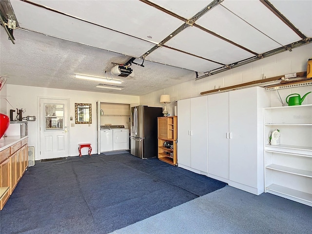 garage featuring stainless steel fridge, independent washer and dryer, and a garage door opener