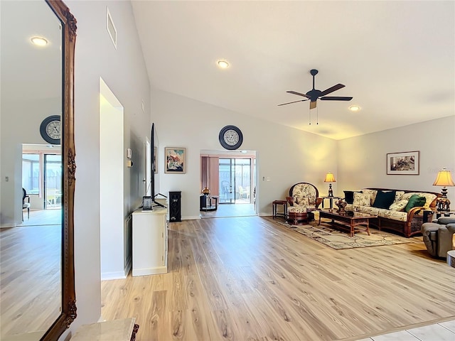 living room with light hardwood / wood-style floors, high vaulted ceiling, and ceiling fan