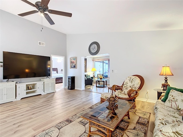 living room featuring ceiling fan, light wood-type flooring, and lofted ceiling