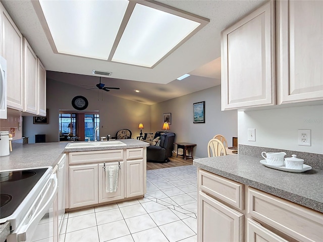 kitchen featuring ceiling fan, sink, kitchen peninsula, electric stove, and light tile patterned flooring