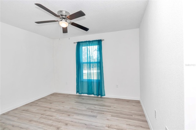 spare room featuring a textured ceiling, light wood-type flooring, and ceiling fan