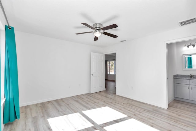 spare room with ceiling fan, sink, and light hardwood / wood-style floors