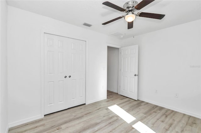 unfurnished bedroom featuring a closet, light hardwood / wood-style flooring, and ceiling fan