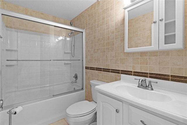 full bathroom featuring vanity, bath / shower combo with glass door, toilet, tile walls, and tasteful backsplash