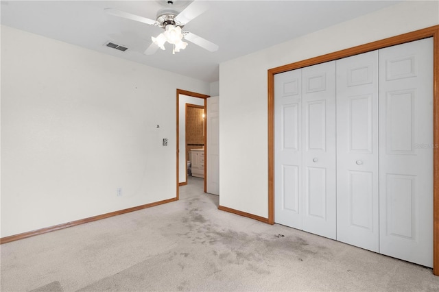 unfurnished bedroom featuring a closet, ceiling fan, and light colored carpet