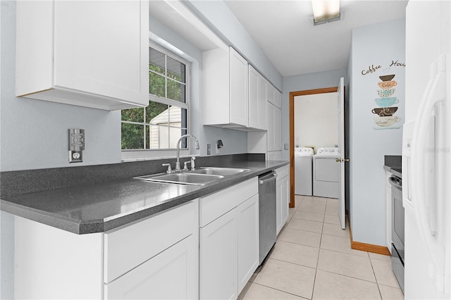 kitchen featuring washer and clothes dryer, sink, light tile patterned flooring, white cabinetry, and stainless steel appliances