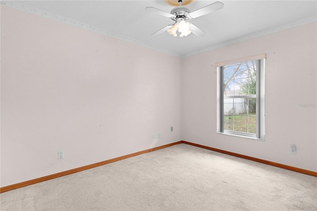 empty room featuring carpet floors, ceiling fan, and crown molding