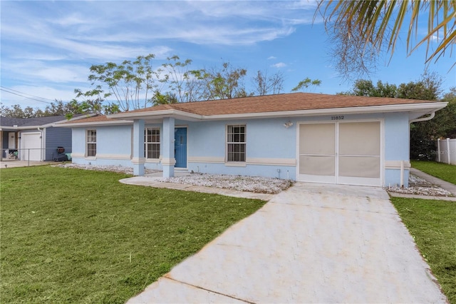 single story home with a garage and a front lawn