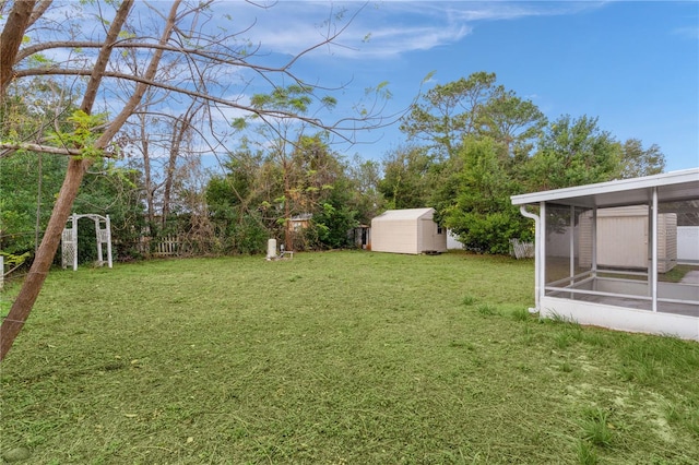 view of yard with a sunroom and a storage shed