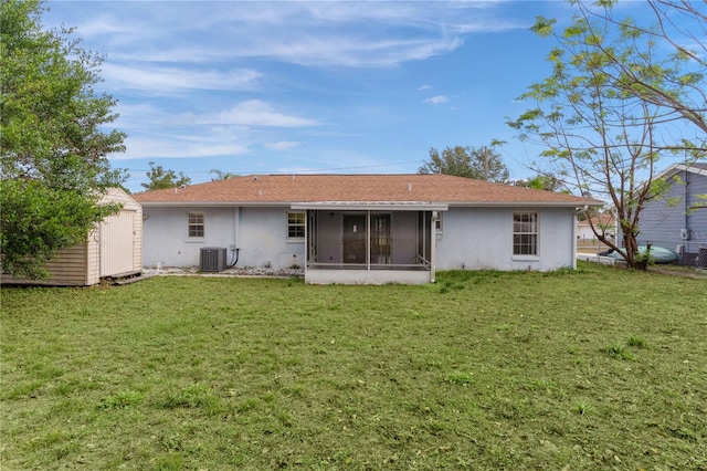 rear view of property with a sunroom, cooling unit, a storage shed, and a yard