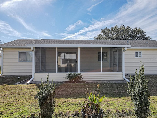 back of property featuring a lawn and a sunroom