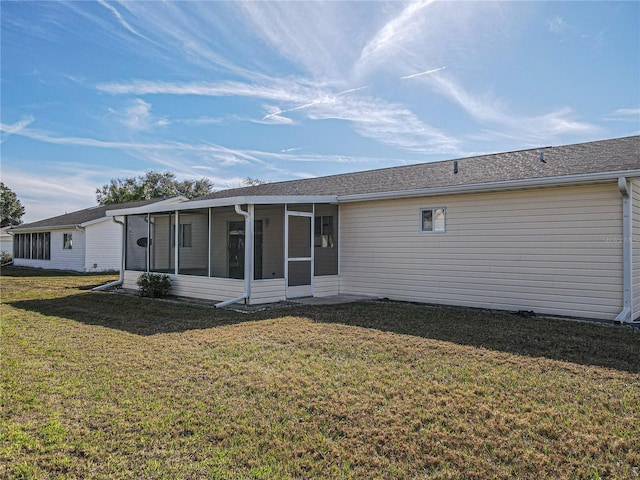 back of property with a sunroom and a yard