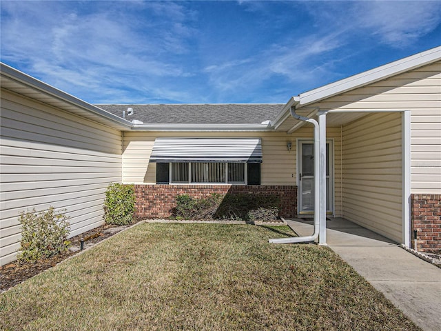 entrance to property with a lawn