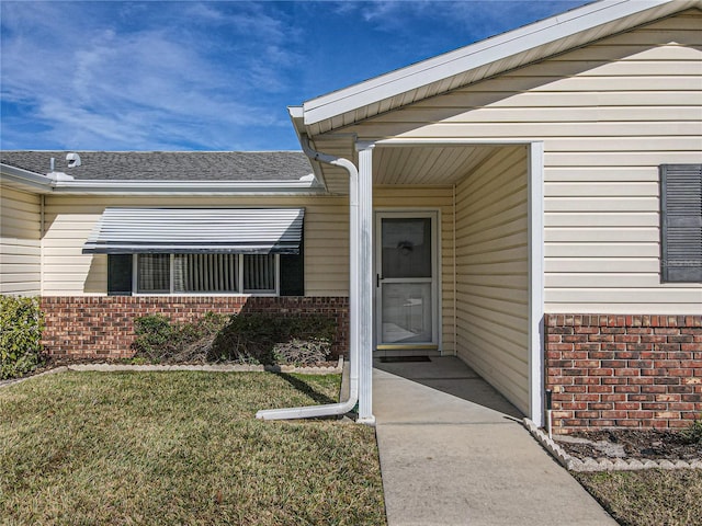 entrance to property with a lawn