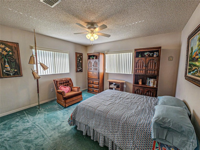 carpeted bedroom featuring ceiling fan and a textured ceiling