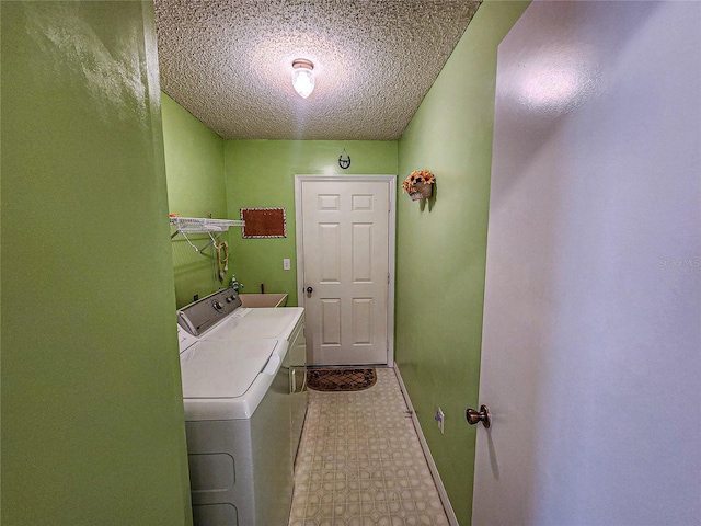 laundry area featuring washing machine and dryer and a textured ceiling