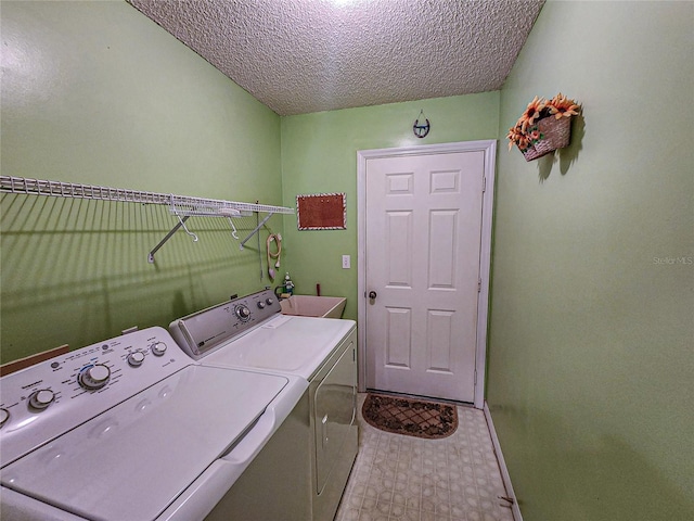 laundry room with sink, washer and dryer, and a textured ceiling