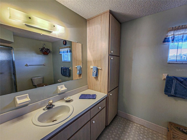 bathroom featuring vanity, a textured ceiling, and toilet