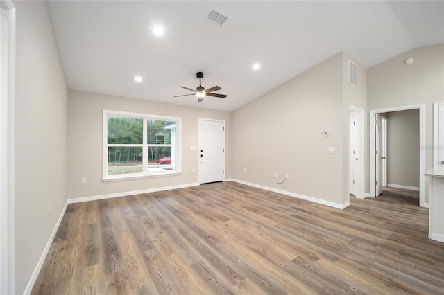 empty room with ceiling fan, vaulted ceiling, and wood-type flooring