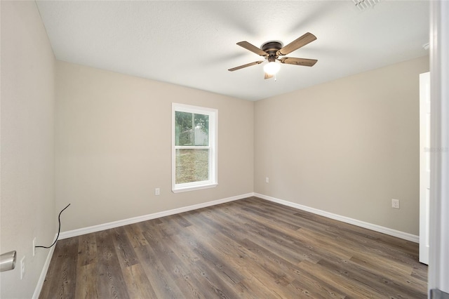 empty room with ceiling fan and dark hardwood / wood-style flooring