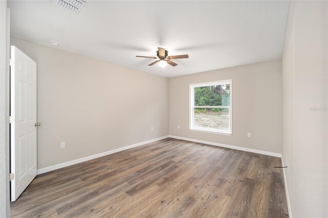 unfurnished room with dark hardwood / wood-style floors and ceiling fan