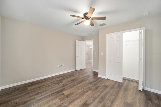 unfurnished bedroom featuring dark wood-type flooring, a closet, and ceiling fan