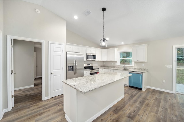 kitchen featuring a kitchen island, appliances with stainless steel finishes, decorative light fixtures, white cabinetry, and sink