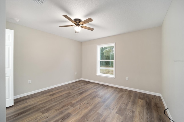 spare room with ceiling fan, dark hardwood / wood-style flooring, and a textured ceiling